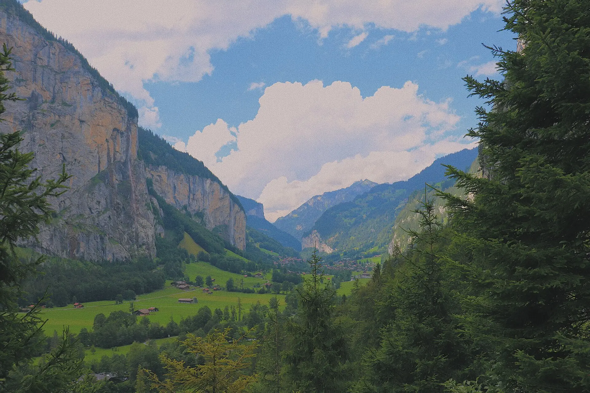 Lauterbrunnen church and chalets on the valley floor with Staubbach Falls dropping from the cliff behind
