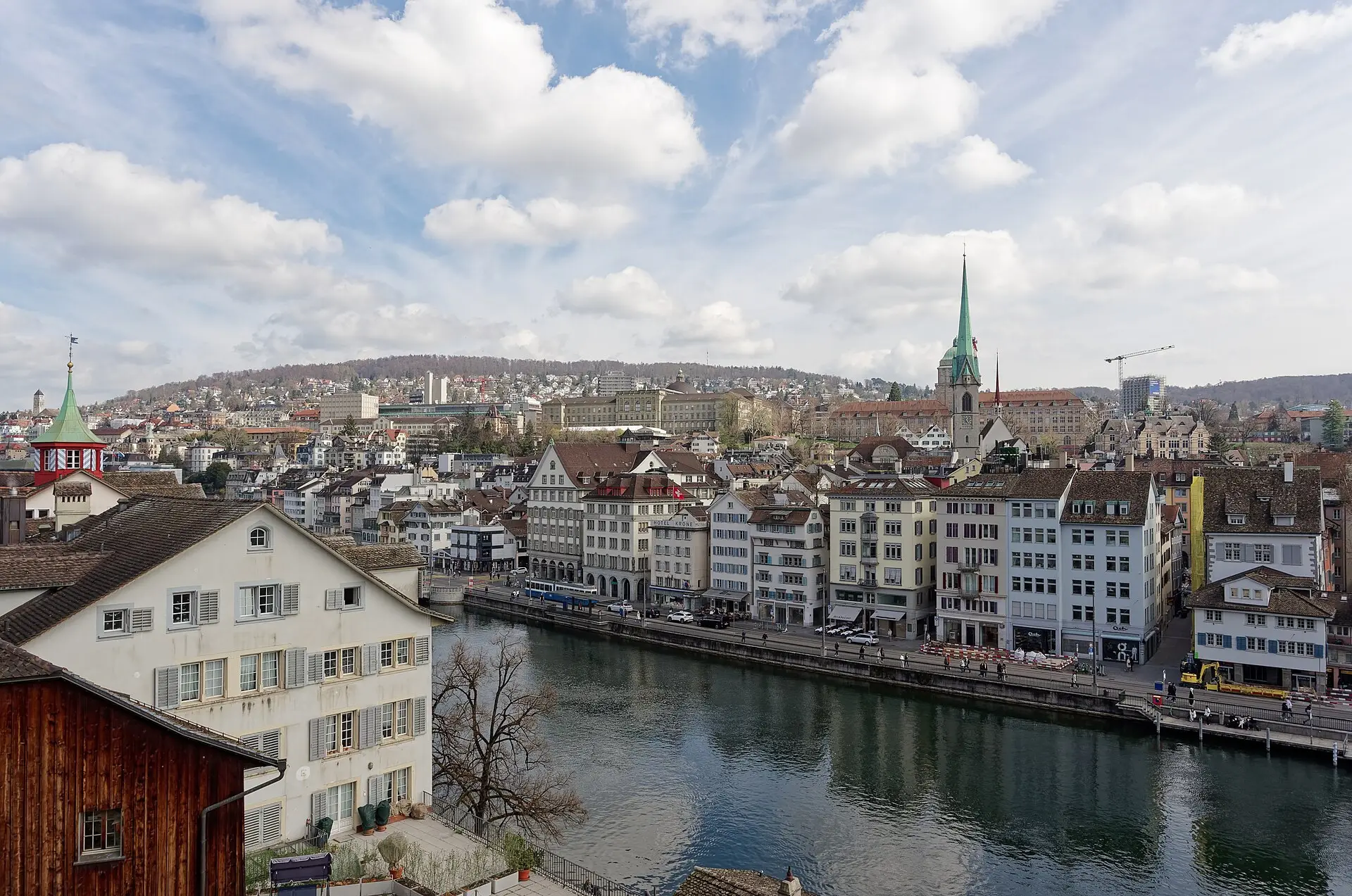 Couple on the Lindenhof terrace in Zurich with the Grossmünster towers across the Limmat